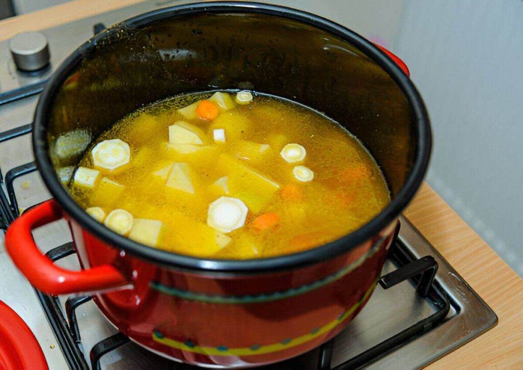 Combine stock, onion, potato, and carrot in the pan and bring to boil.