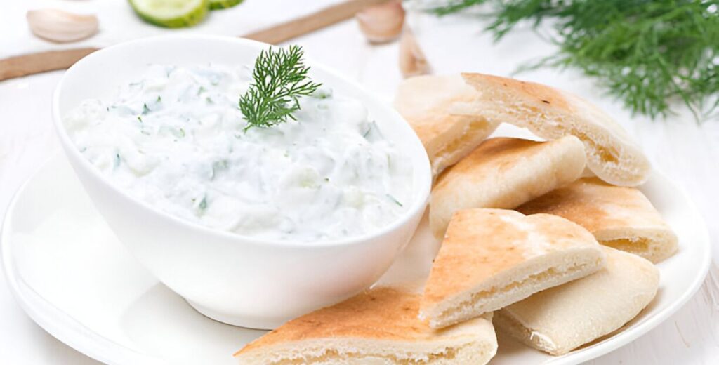 Tzatziki Sauce in a bowl with pitta breads